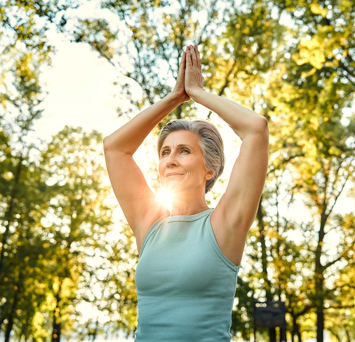 A peaceful midlife woman stands in a yoga pose