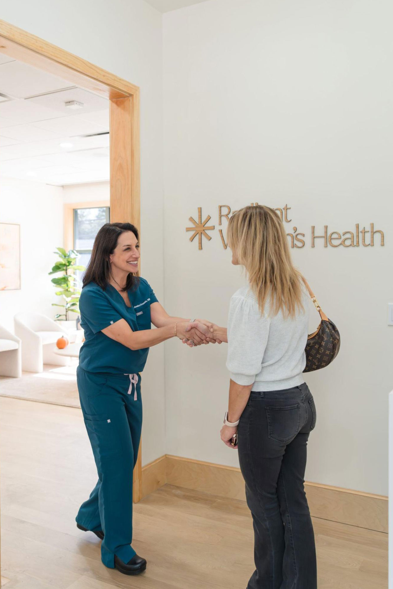 A bright, clean doctor’s desk with a laptop, flowers, and various medical items