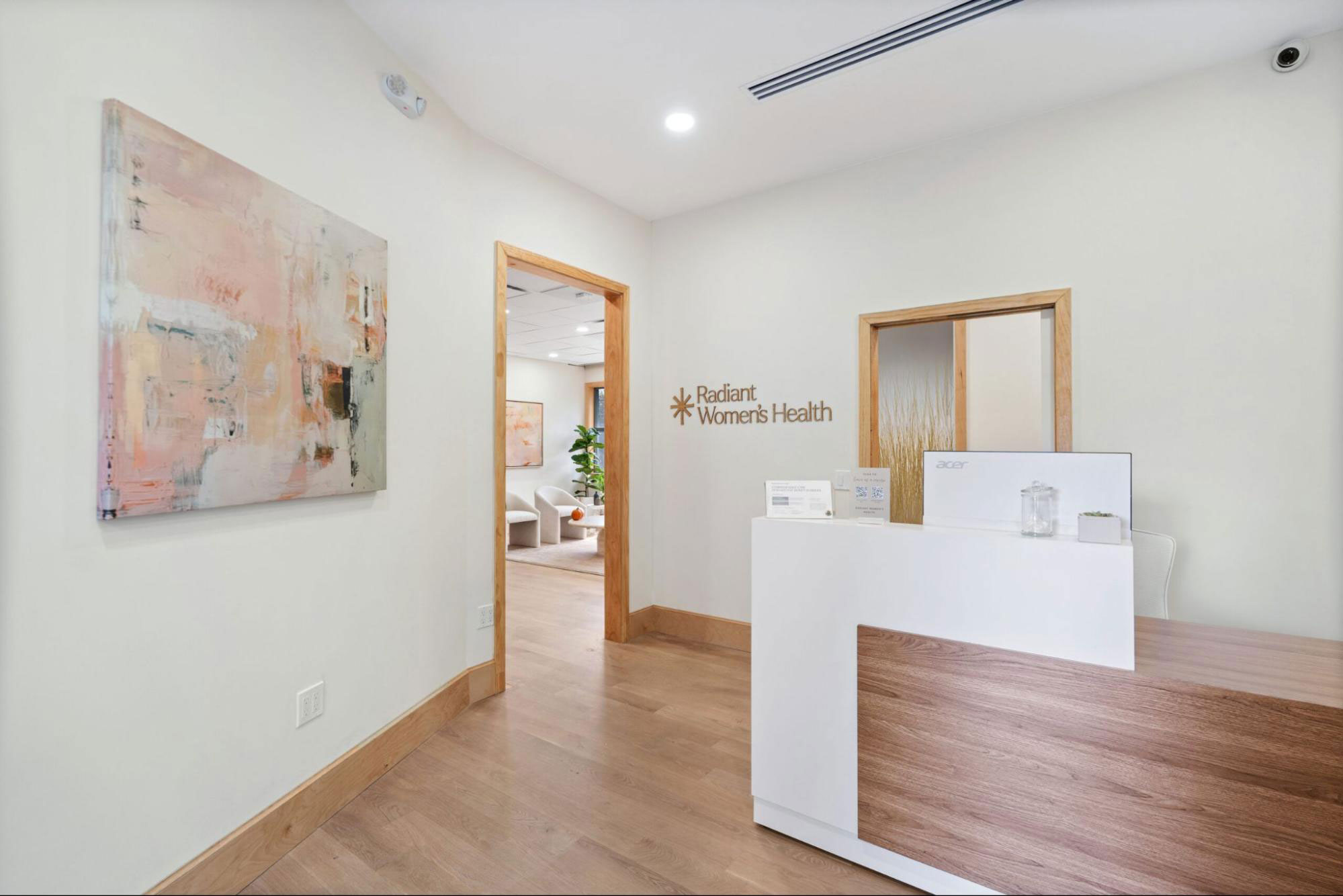 A bright, clean doctor’s desk with a laptop, flowers, and various medical items